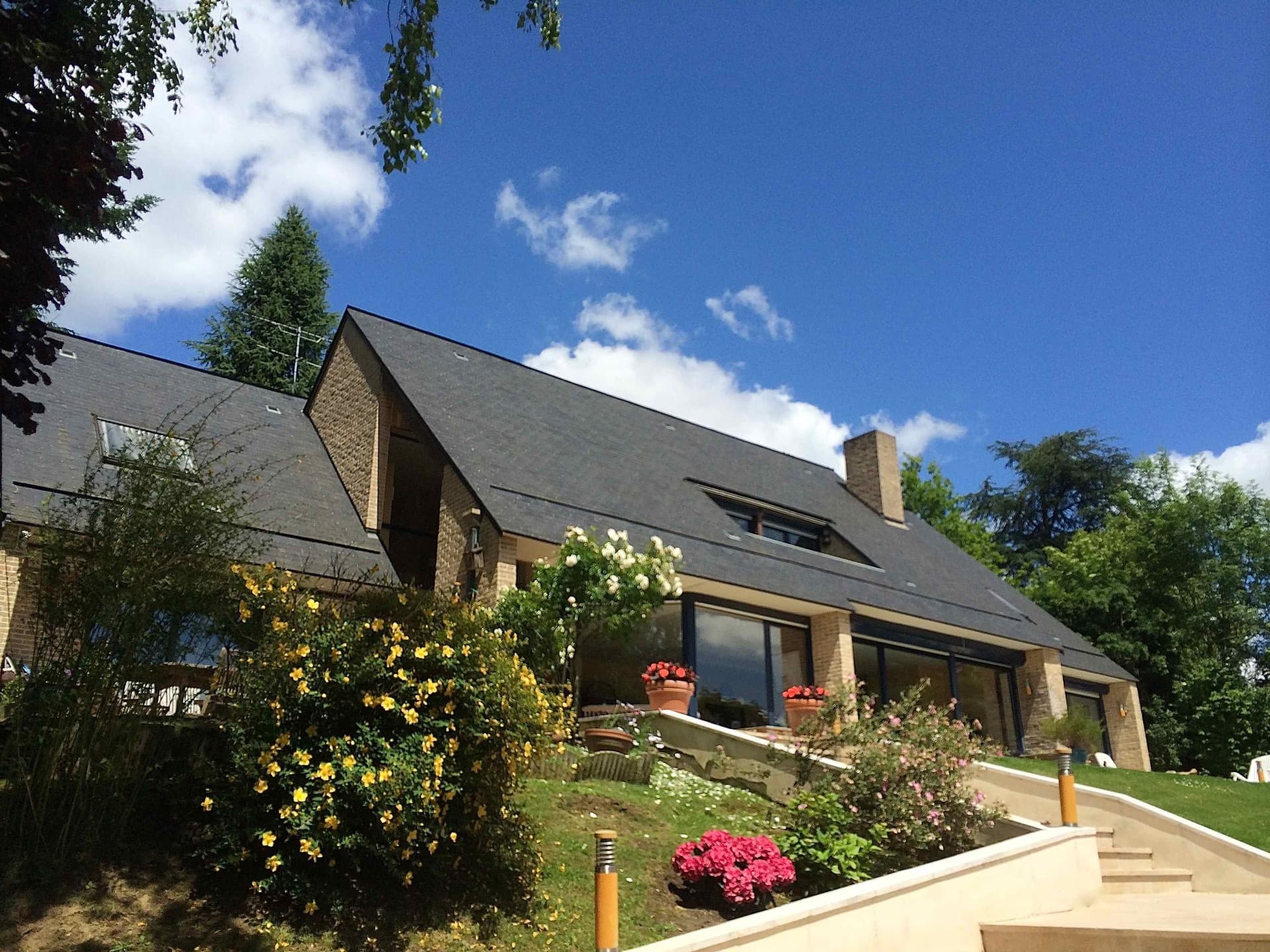 Façade côté jardin avec terrasse en pierre