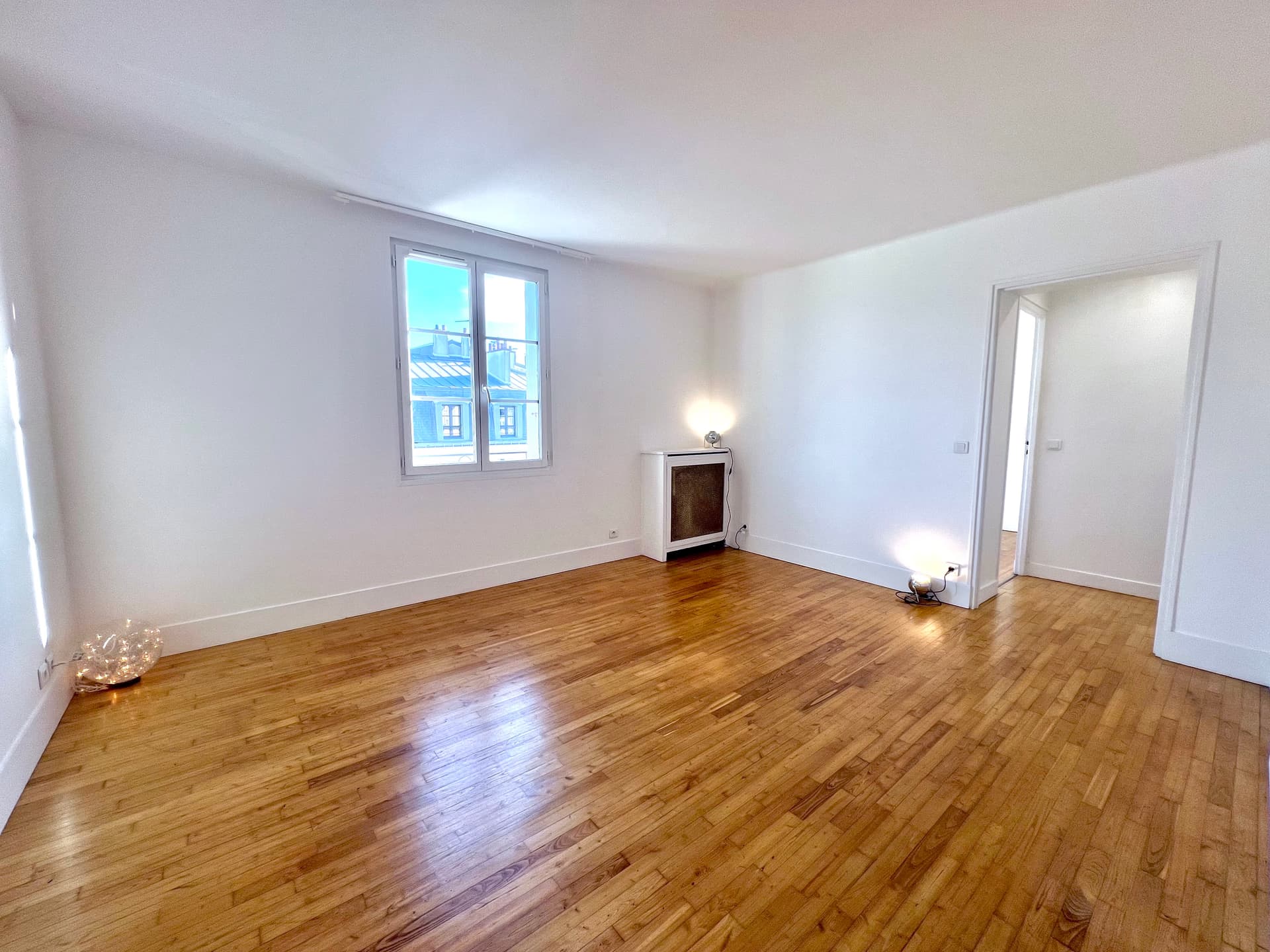 Séjour haussmannien exposé Sud avec parquet restauré